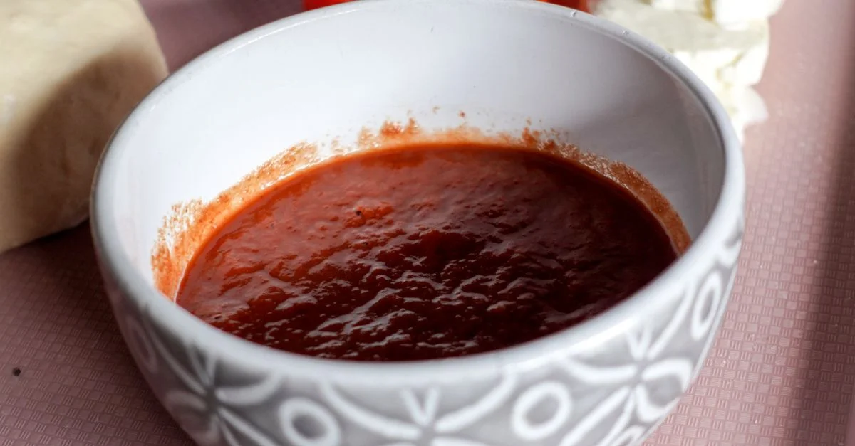 Un bol de sauce tomate entouré de mozzarella et de tranches de tomates, parfait pour la cuisine italienne.