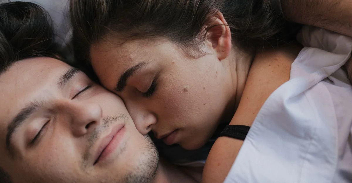 Un gros plan d'un couple intime se blottissant et se reposant ensemble dans le lit.
