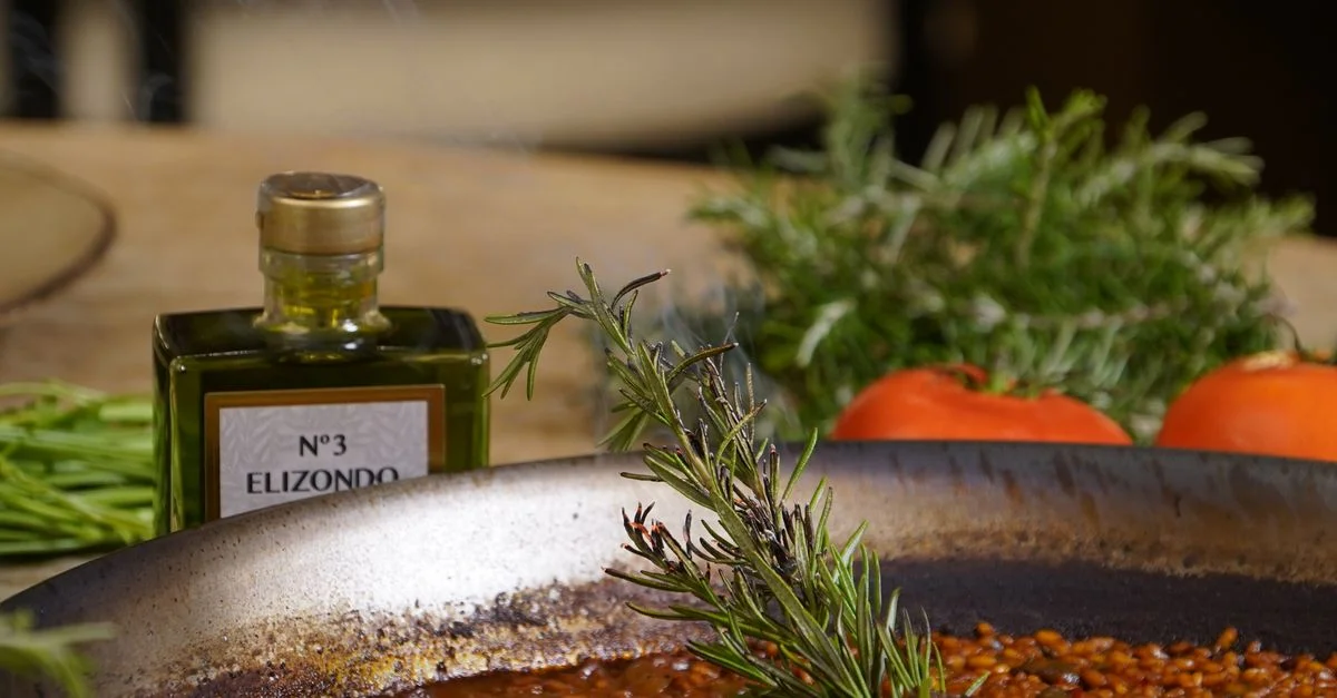Gros plan sur une paella traditionnelle au romarin et à l'huile d'olive, mettant en valeur la fraîcheur des ingrédients méditerranéens.