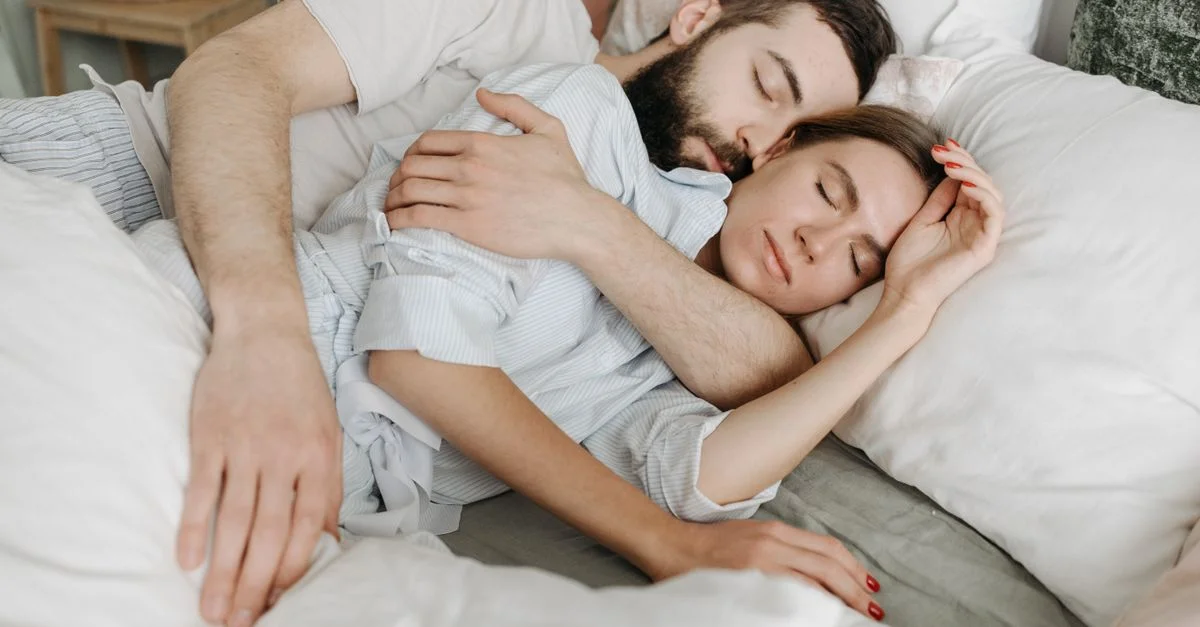 Un couple amoureux s'étreint chaleureusement dans une chambre confortable.