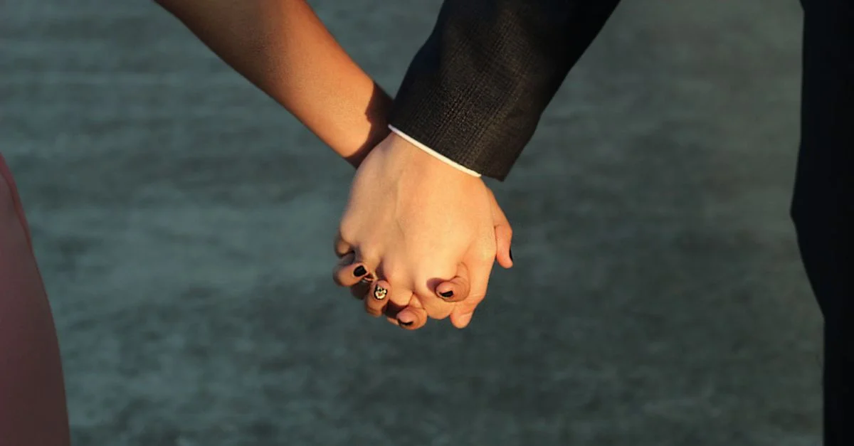 Un couple tenant ses mains à l'extérieur, symbolisant l'amour et la connexion.