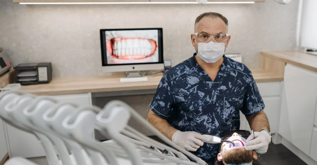 Clinique dentaire moderne avec un dentiste examinant un patient pour sa santé bucco-dentaire.