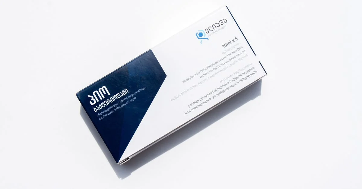 Une boîte de médicaments avec du texte en anglais et en géorgien, isolée sur un fond blanc pour des besoins de santé.