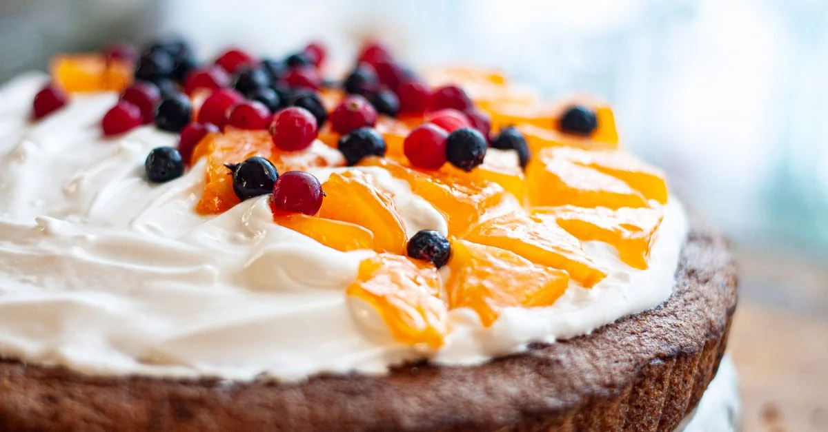 Délicieux gâteau au chocolat fait maison garni de crème onctueuse, de fruits frais et de baies.