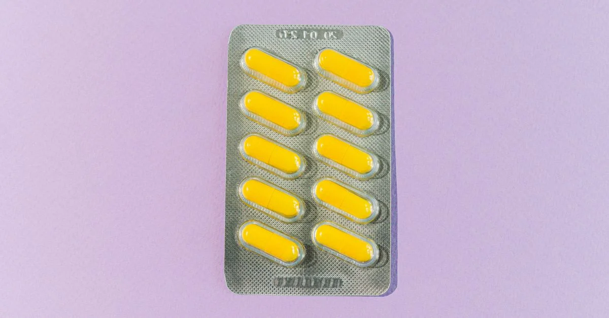 Une plaquette de pilules jaunes sur un fond violet, symbolisant la santé et les médicaments.