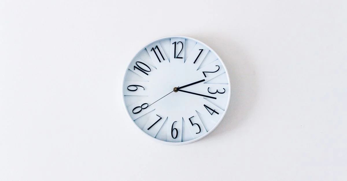Horloge murale simple et minimaliste sur un mur blanc pour une esthétique épurée.