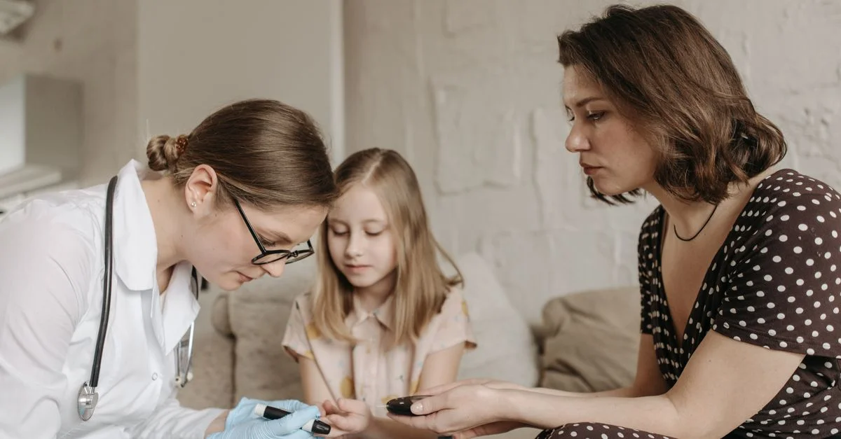Un pédiatre contrôle le taux de sucre dans le sang d'un enfant pendant que sa mère l'assiste à la maison.