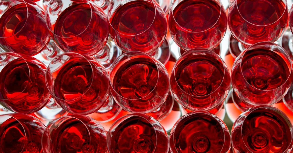 Une vue captivante de plusieurs verres à vin rouge avec un reflet miroir saisissant.