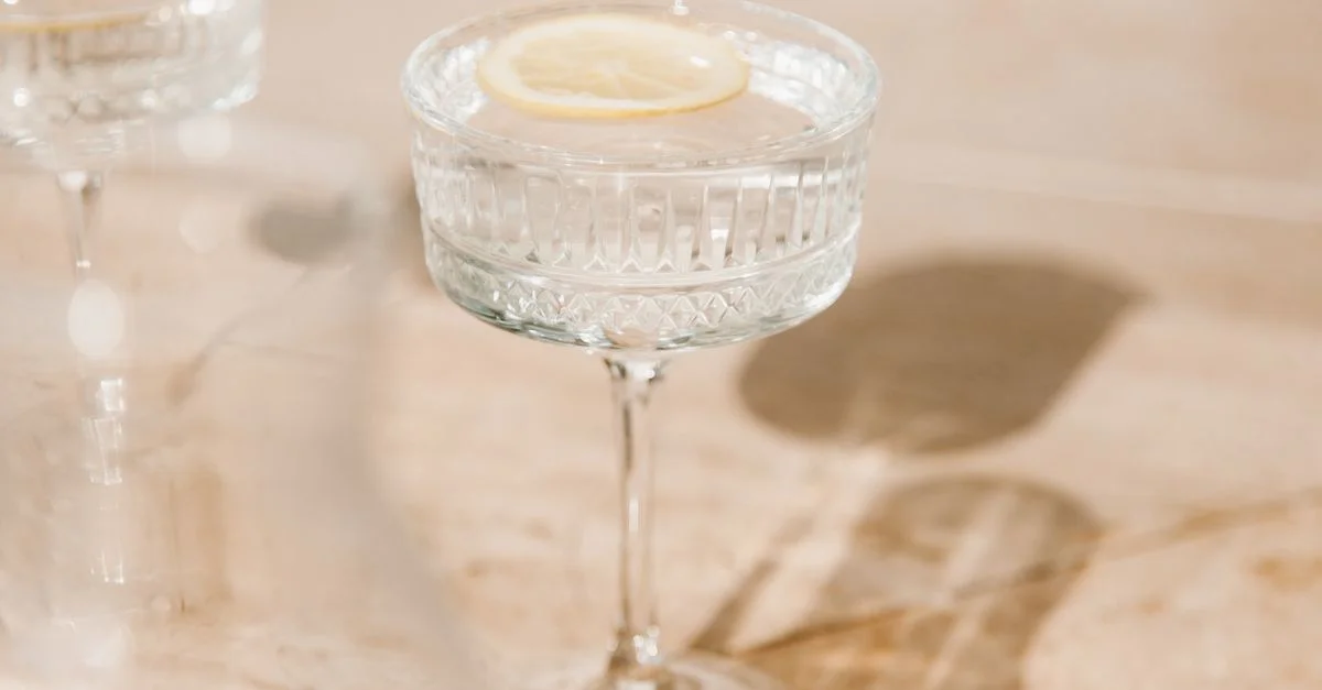 Prise esthétique d'eau citronnée dans un verre en cristal avec lumière naturelle et ombres.