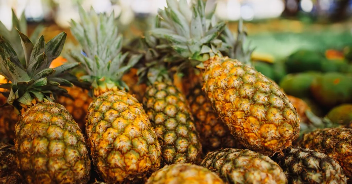 Une exposition dynamique d'ananas frais sur un marché en plein air, mettant en valeur leur texture et leur couleur riches.