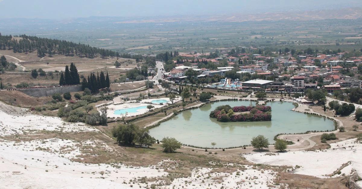 Vue aérienne des emblématiques piscines thermales de Pamukkale et de ses paysages pittoresques par une journée ensoleillée.