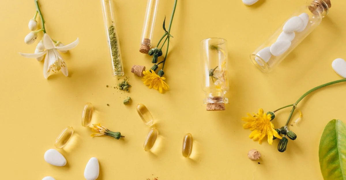 Un agencement d'herbes médicinales, de pilules et de fleurs sur une surface jaune vif, mettant en avant les soins de santé naturels.