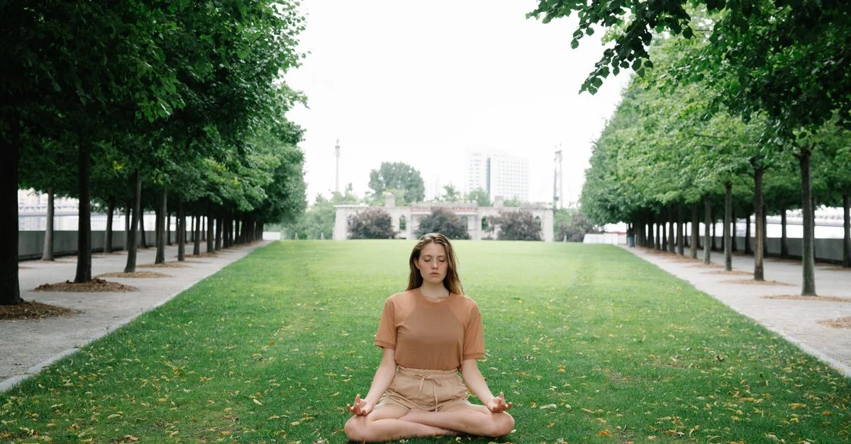 Femme pratiquant la méditation de yoga dans un parc verdoyant paisible