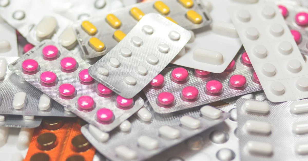 Gros plan sur divers comprimés colorés dans des packs de médicaments, montrant un assortiment de médicaments.