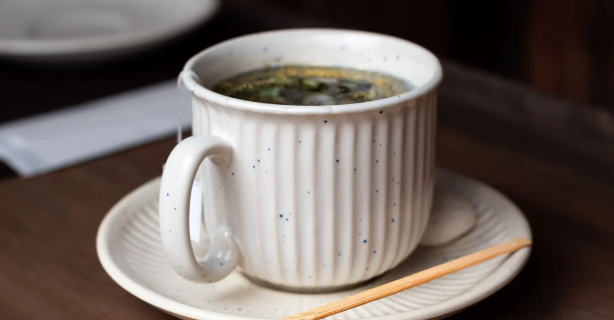 Un gros plan d'une tasse en céramique remplie de thé à la camomille sur une table en bois à São Paulo.