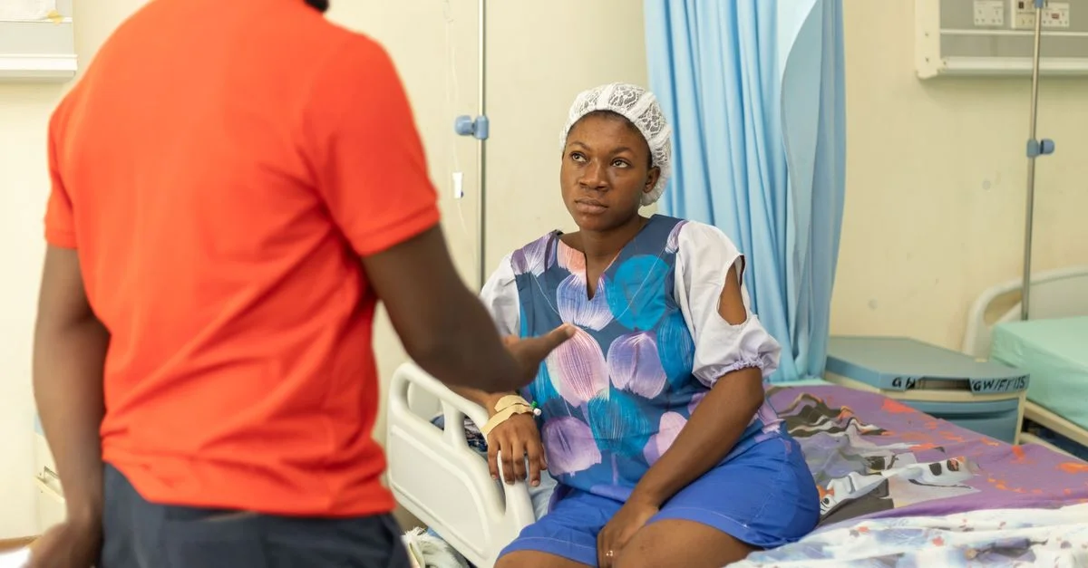 Personnel médical s'adressant à un patient dans une chambre d'hôpital, illustrant une interaction dans le domaine des soins de santé.