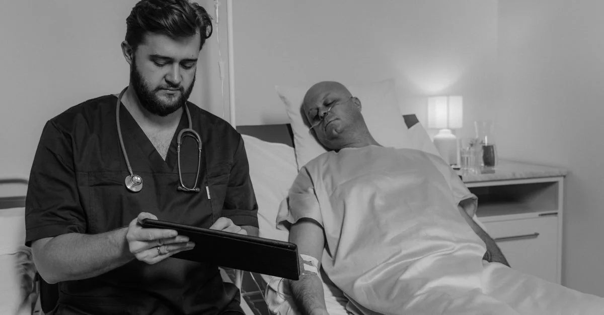 Médecin examinant les données du patient sur une tablette dans une chambre d'hôpital.