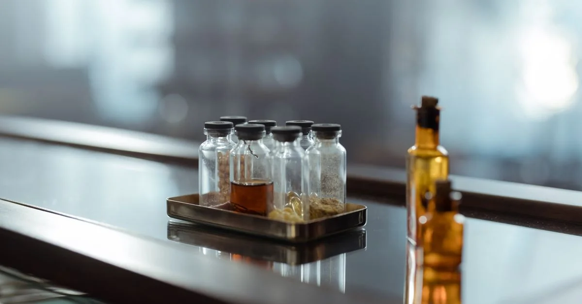 Une disposition captivante de flacons de médicaments sur une surface réfléchissante, évoquant un sens de la chimie et de l'alchimie.