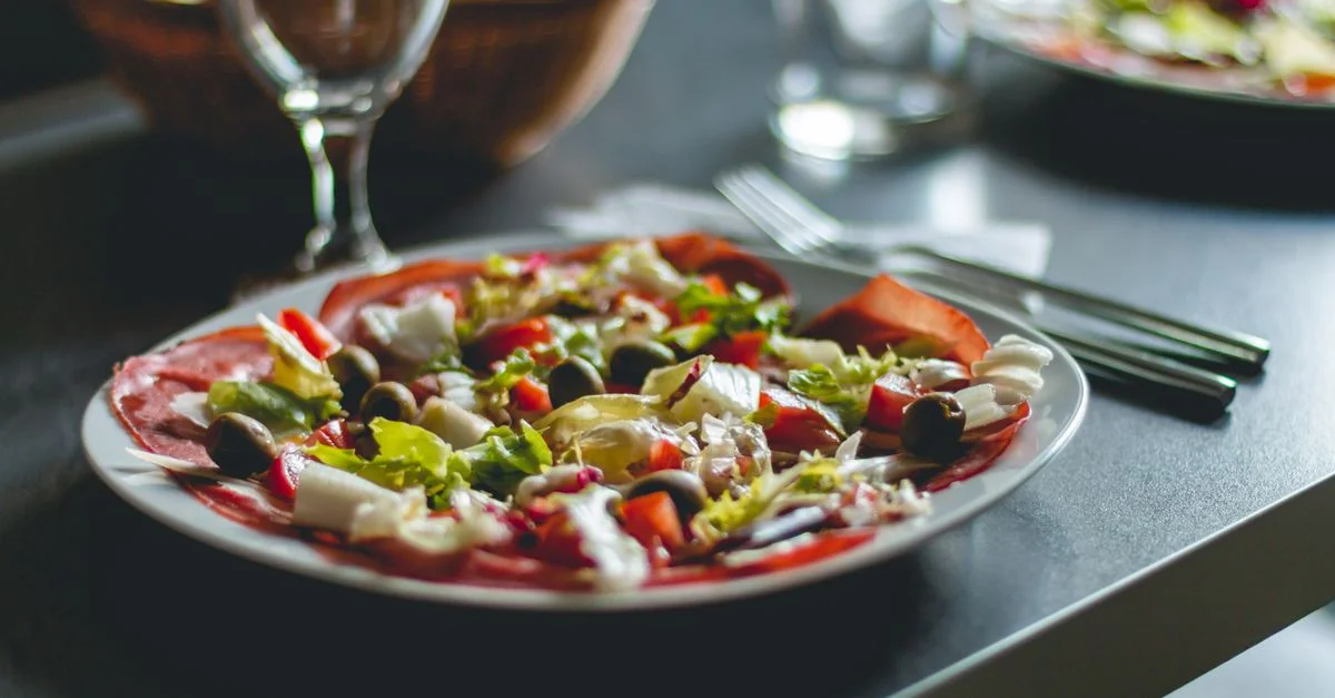 Salade méditerranéenne attrayante avec des olives, du fromage et des légumes frais sur une assiette en céramique.