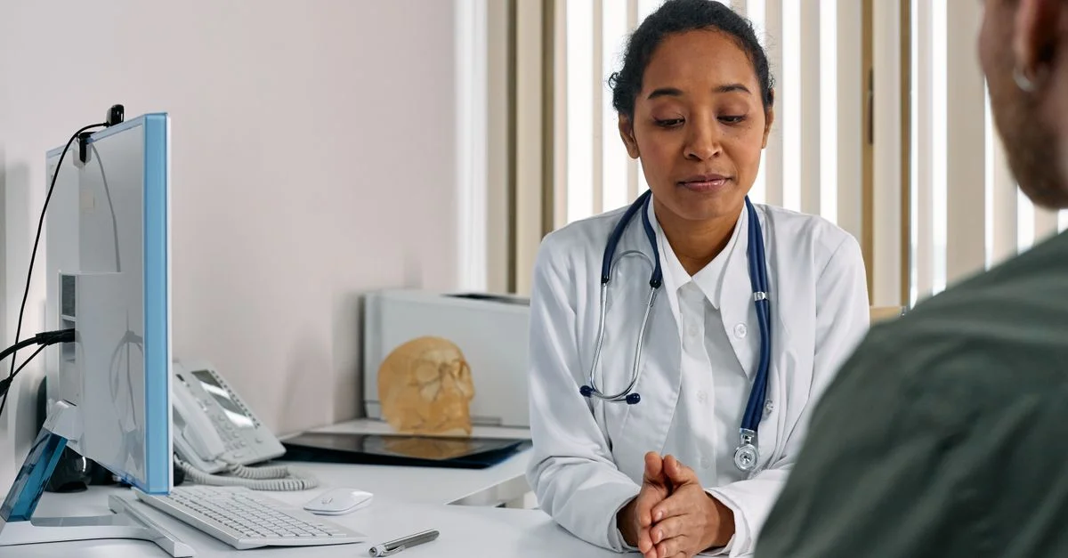 Une médecin femme consultant un patient dans un cadre médical moderne.