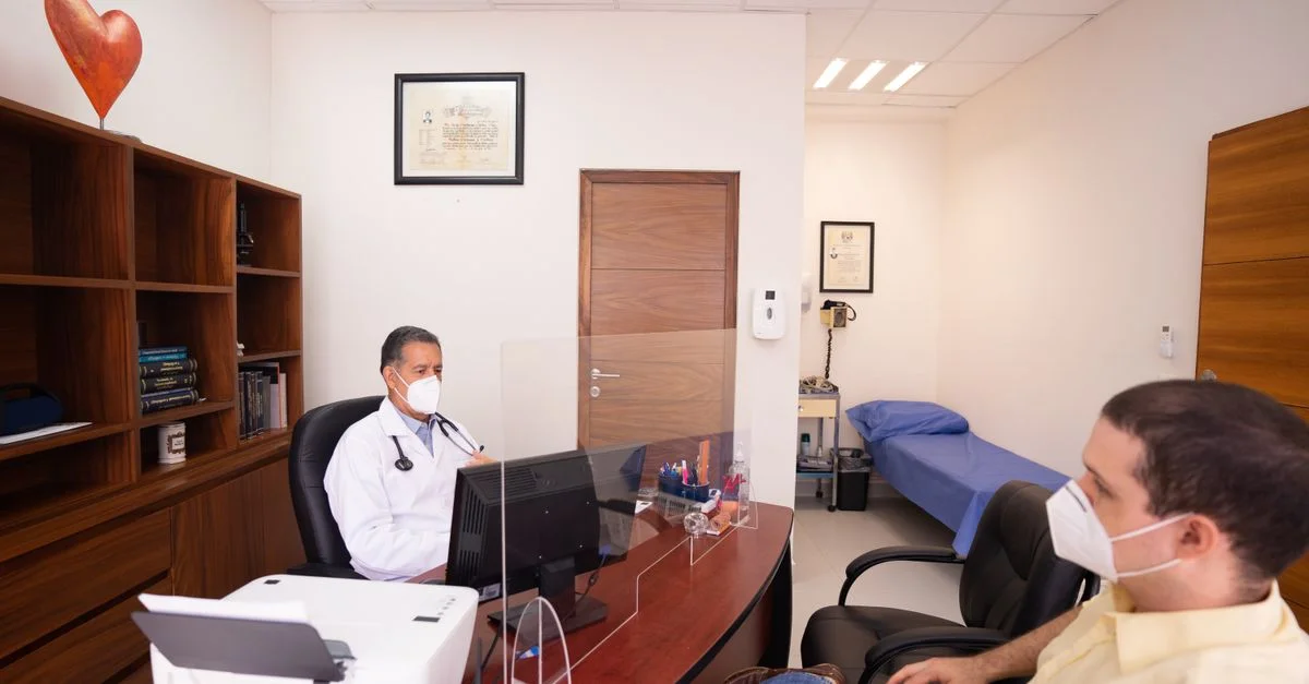 Médecin et patient avec des masques dans une clinique médicale, mettant l'accent sur la sécurité en santé.