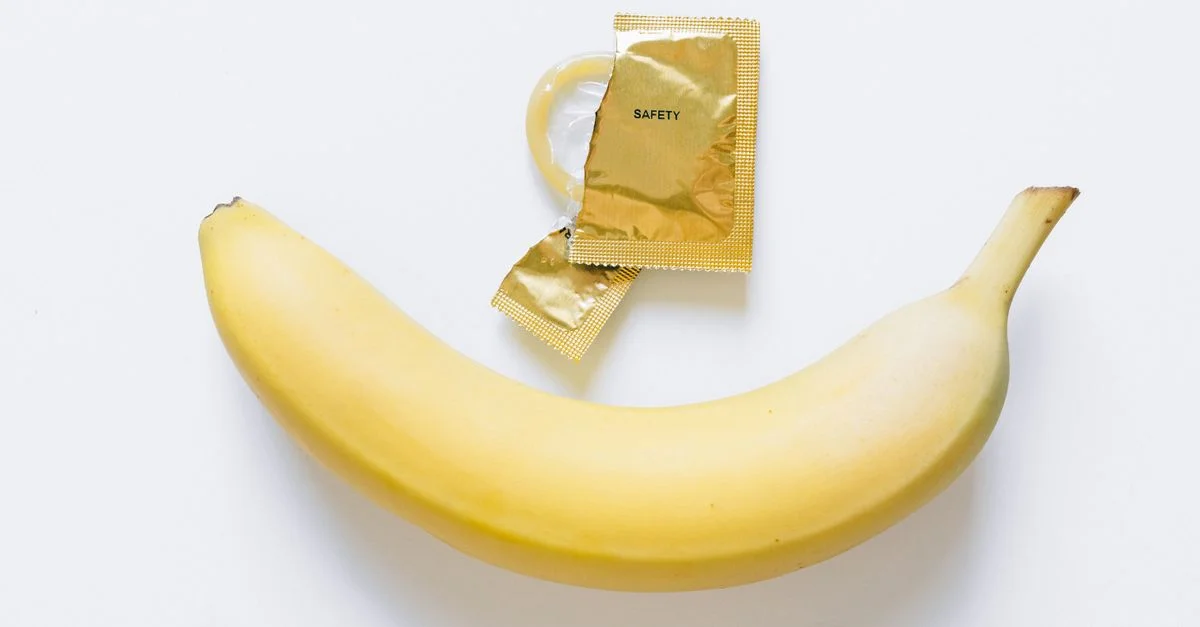 Image d'une banane et d'un préservatif, symbolisant l'éducation à la santé et les pratiques de sexe sûr.