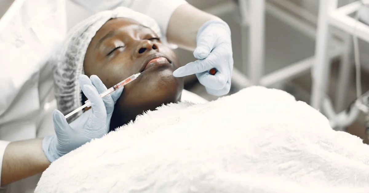 Une femme recevant une injection esthétique avec une seringue dans un cadre médical.