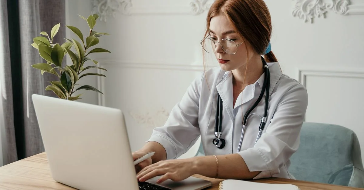 Une femme médecin utilisant un ordinateur portable dans un cadre moderne de soins de santé.