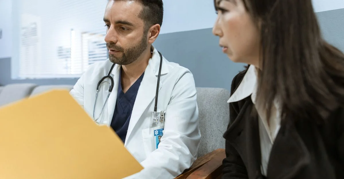 Le médecin discute des dossiers de santé avec un patient dans un cadre clinique.