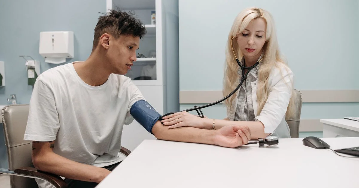 Un médecin mesure la pression artérielle d'un patient dans un cadre clinique, mettant l'accent sur les soins de santé et le bien-être.