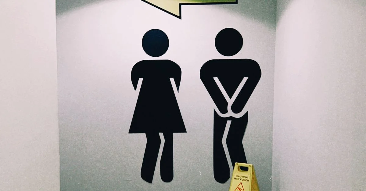 Signalisation de direction des toilettes modernes à l'intérieur d'un centre commercial à Almaty, au Kazakhstan, avec un panneau d'avertissement concernant le sol mouillé.