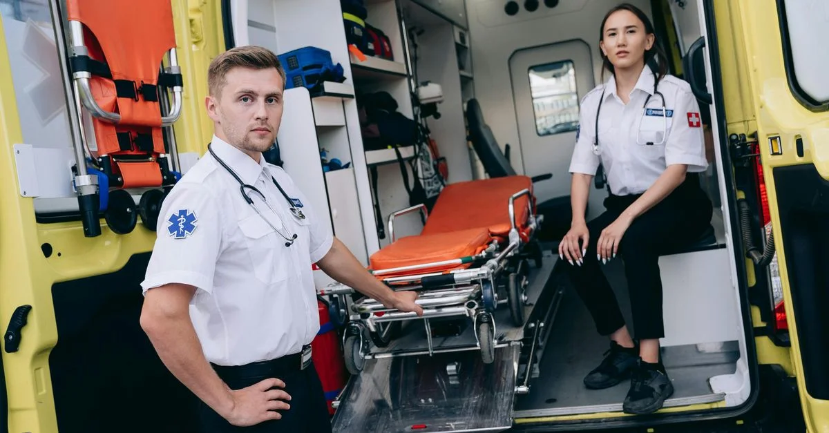 Des paramedics se préparent pour une urgence avec du matériel médical dans une ambulance.