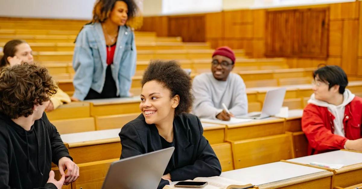 Un groupe diversifié d'étudiants participant à une discussion dans un amphithéâtre universitaire.