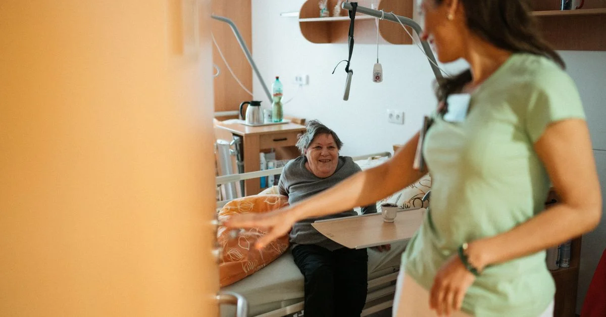 Une infirmière interagit chaleureusement avec un patient âgé dans l'environnement confortable d'une maison de retraite.