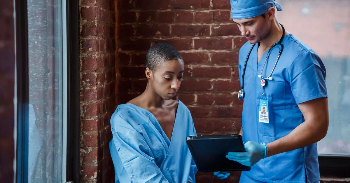 Infirmière et patient participant à une consultation médicale à l'intérieur avec un clipboard.