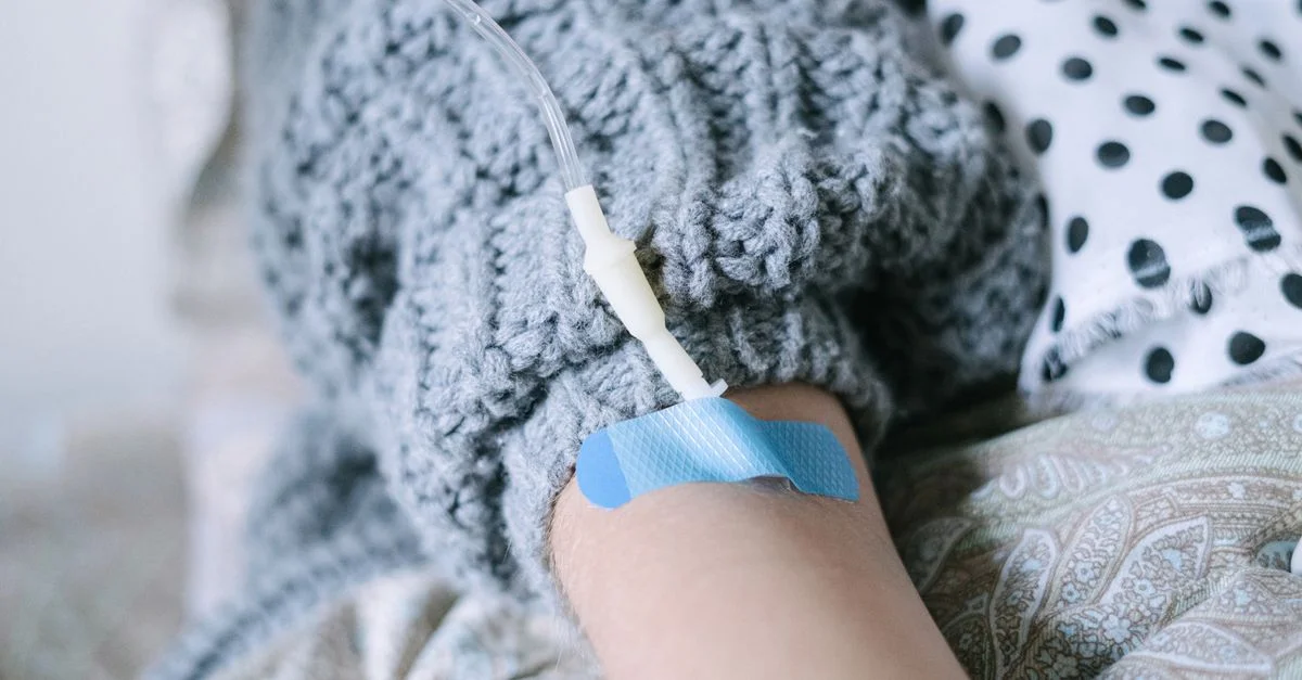 Gros plan d'une patiente recevant une thérapie intraveineuse pendant un traitement du cancer.