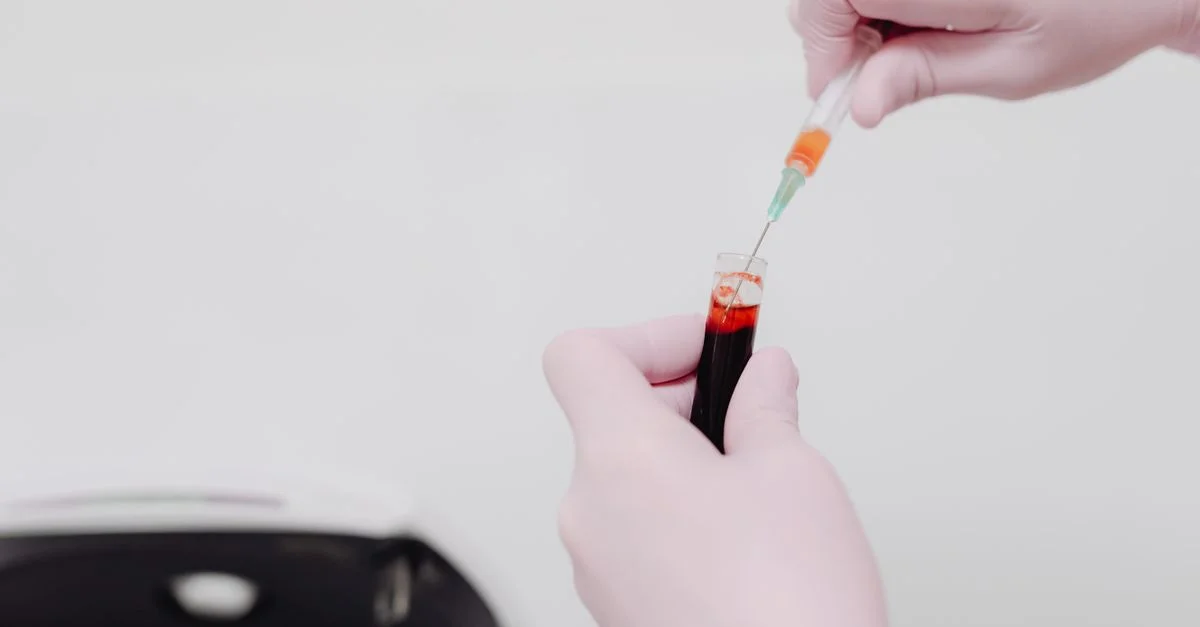 Technicien de laboratoire utilisant une seringue pour manipuler un échantillon de sang. Concept d'analyse médicale.