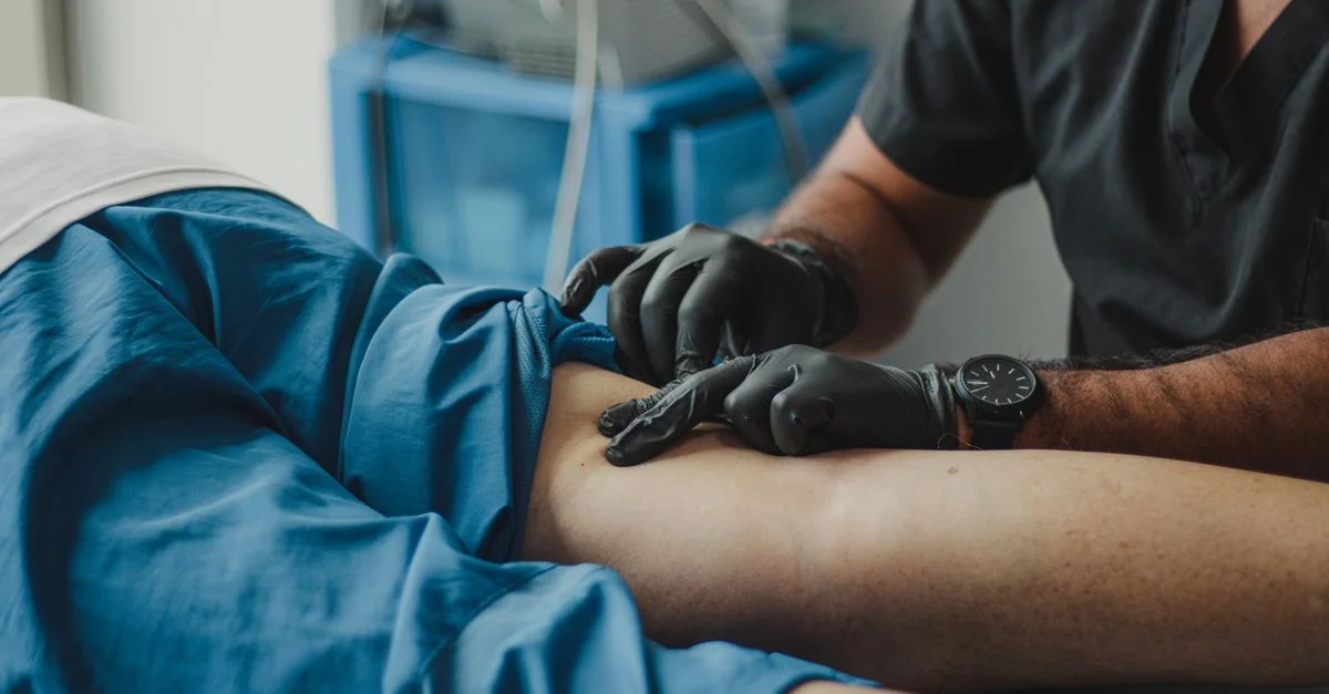 Un professionnel de santé en gants fournit un traitement à un patient dans un cadre médical.