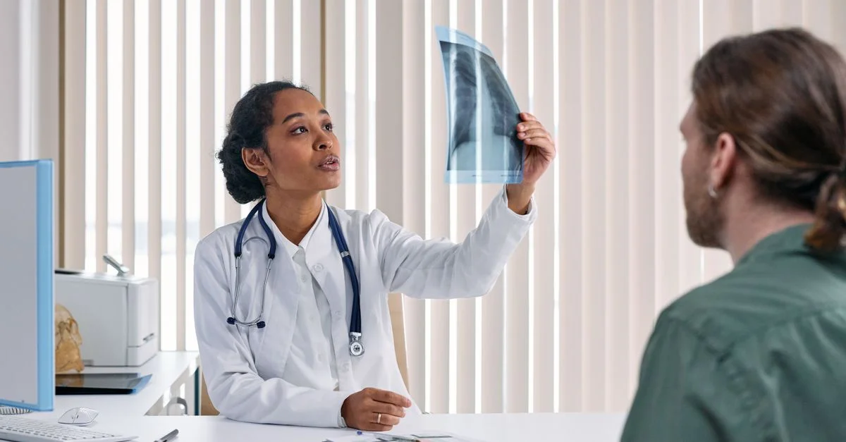 Médecin femme examine les résultats de radiographie avec un patient masculin dans un environnement médical.