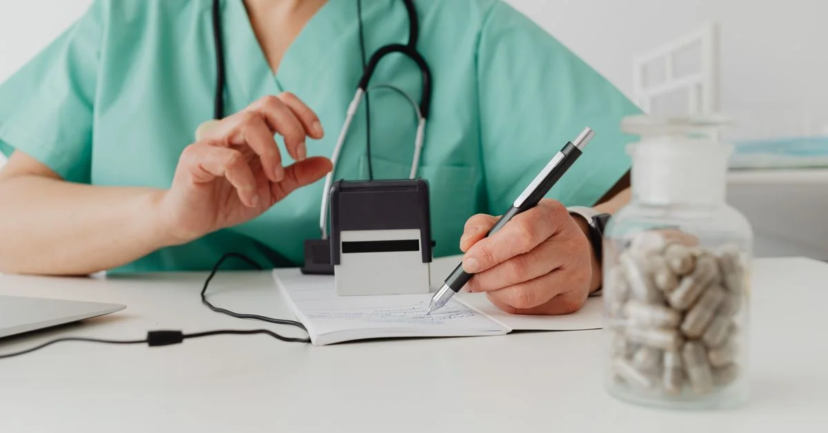 Un professionnel de la santé écrivant une ordonnance dans un cadre clinique.