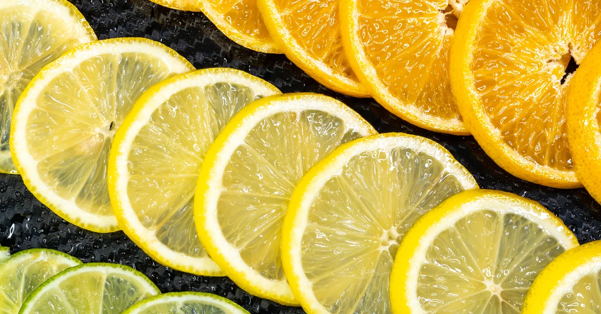 Arrangement coloré de tranches d'agrumes comprenant des oranges, des citrons et des citrons verts pour une ambiance rafraîchissante et saine.