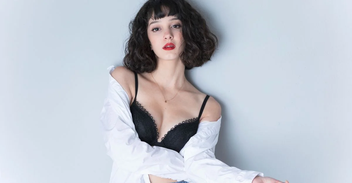 Portrait élégant d'une femme en chemise blanche et soutien-gorge noir. Parfait pour des éditoriaux de mode et du contenu lifestyle.