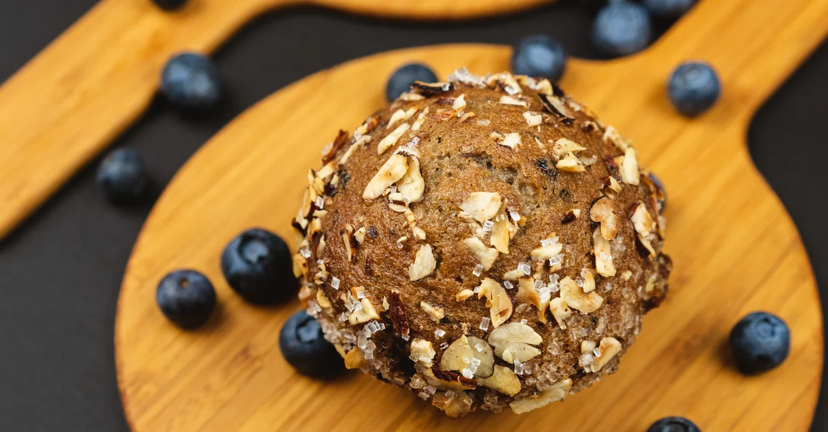 Vue de dessus de muffins frais aux myrtilles avec des flocons d’avoine et des myrtilles éparpillées.