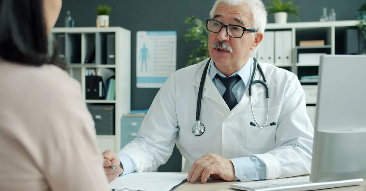 Un médecin expérimenté consulte un patient dans un cabinet médical.