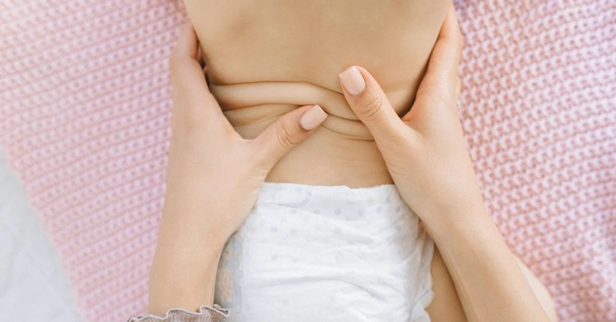 Un massage apaisant pour un bébé sur une douce couverture rose, favorisant la relaxation.