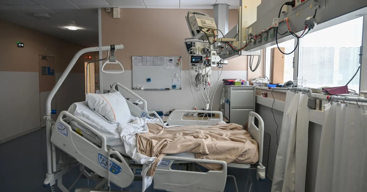 Une chambre d'hôpital vide avec un lit et du matériel médical, idéale pour les thèmes liés à la santé.