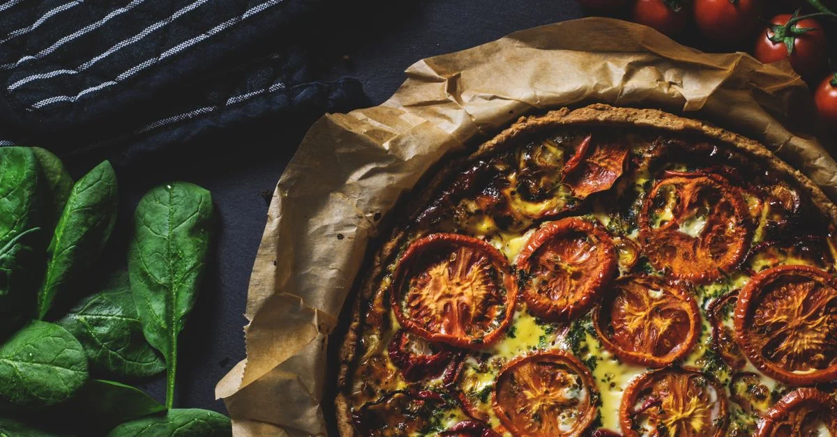 Délicieuse quiche rustique garnie de tomates, idéale pour un repas sain et savoureux.