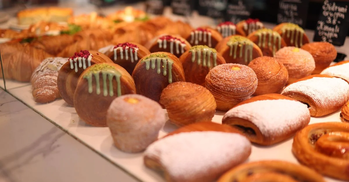 Une vitrine tentante d'assortiments de pâtisseries dans une boulangerie, mettant en valeur une riche variété et des textures.