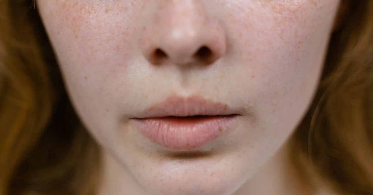 Gros plan détaillé d'un visage féminin tacheté, mettant l'accent sur les caractéristiques naturelles et les textures.