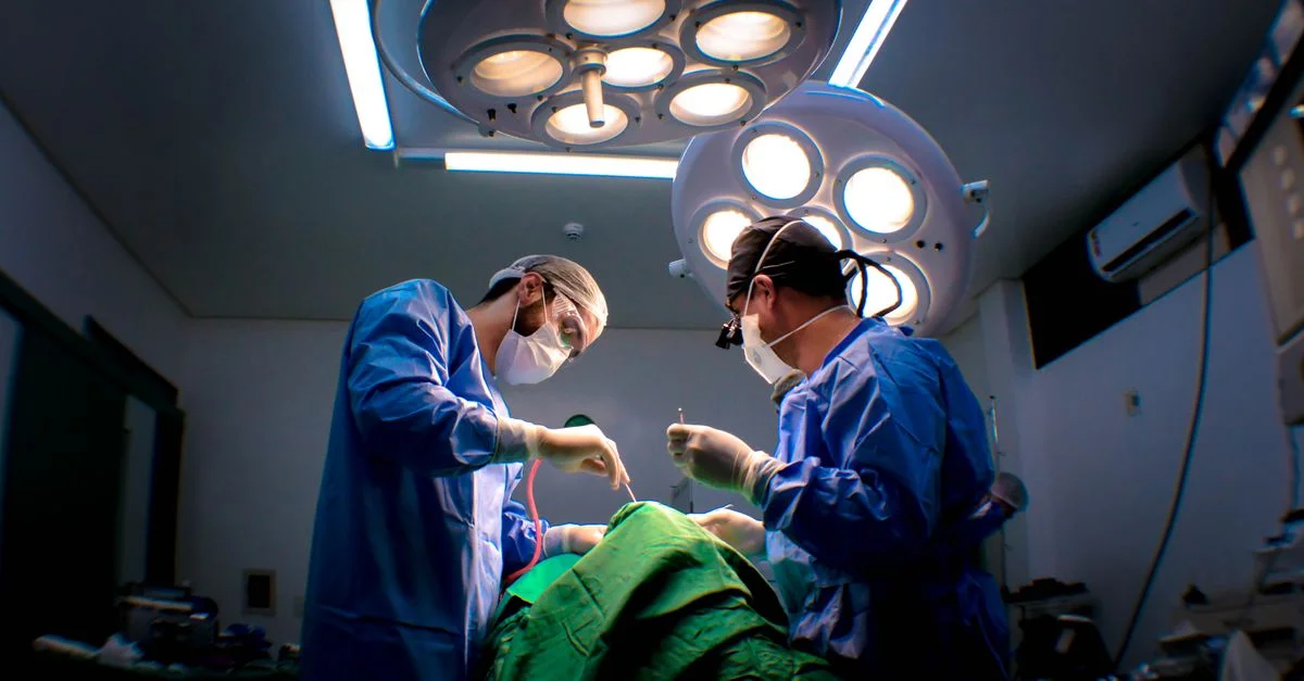 Deux chirurgiens pratiquant une chirurgie dans une salle d'opération bien équipée.